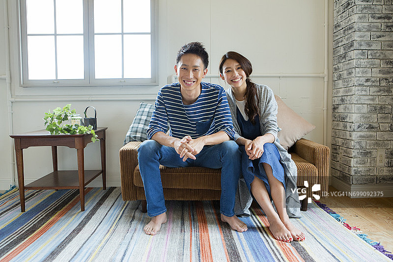 一对年轻夫妇的肖像，坐在沙发上图片素材