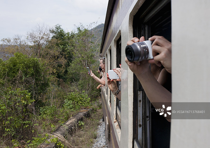 游客从火车窗外拍照，这是泰国北碧府附近的缅甸铁路，又名死亡列车图片素材