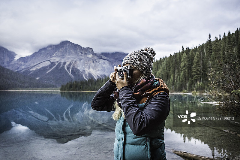在加拿大不列颠哥伦比亚省田野的Yoho国家公园，一位女士正在拍摄翡翠湖的景色图片素材