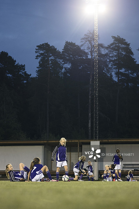 运动员在足球场上靠在树上放松的表面水平的观点图片素材