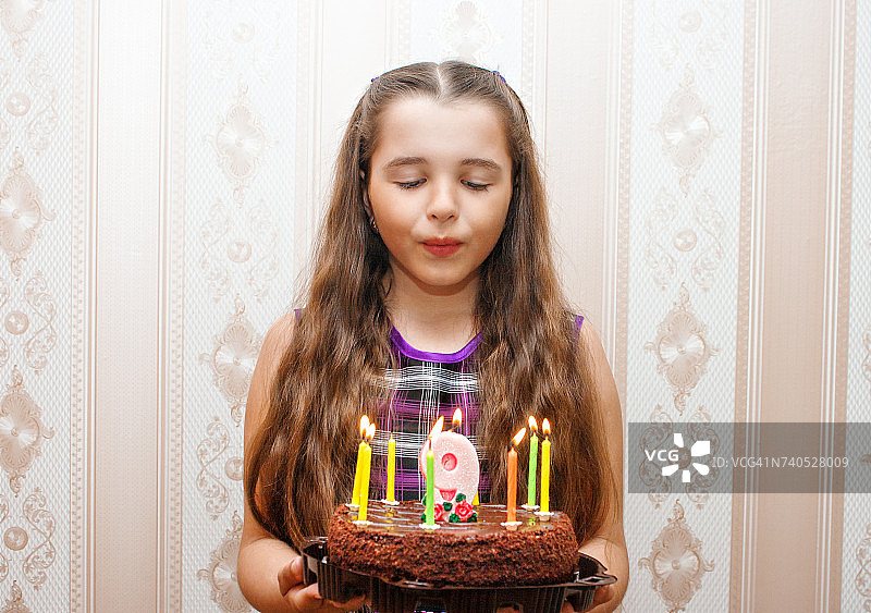 女孩吹灭生日蛋糕上的蜡烛图片素材