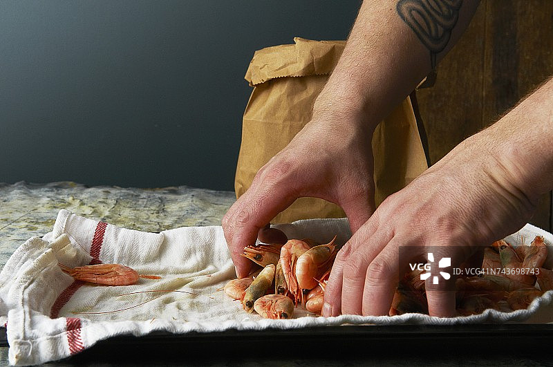 一个厨师在纸袋里装满熟虾图片素材