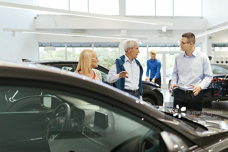 销售人员为汽车经销商的客户提供咨询图片素材