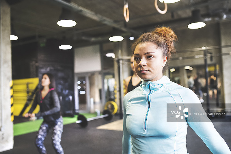 年轻女子与训练伙伴在健身房锻炼图片素材
