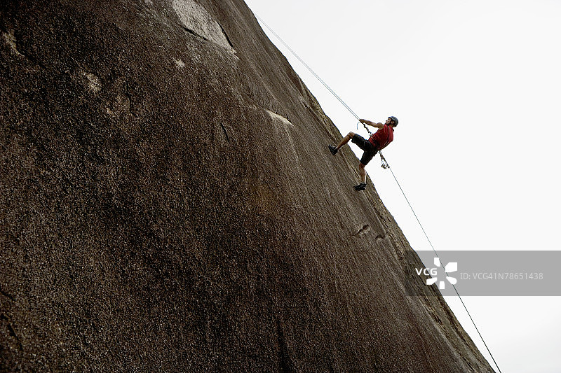 男人在陡峭的悬崖上攀岩图片素材