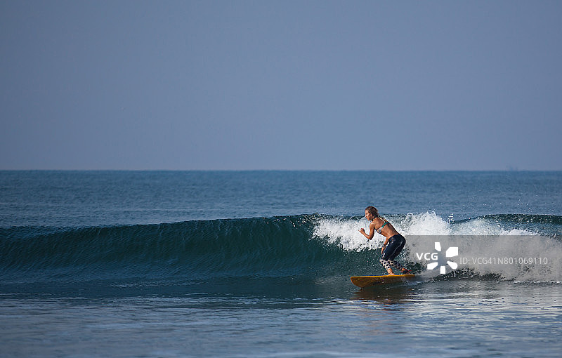 冲浪者女孩在巴厘岛冲浪图片素材
