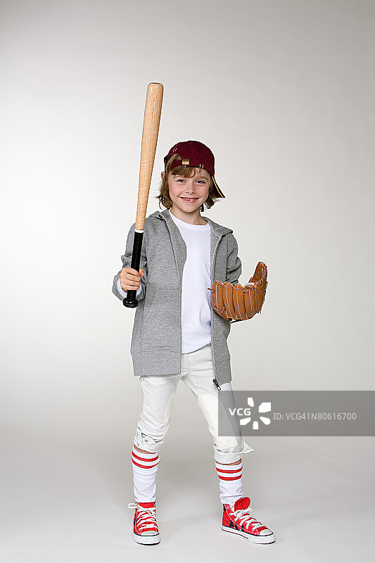 一个拿着棒球棒戴着手套的男孩图片素材