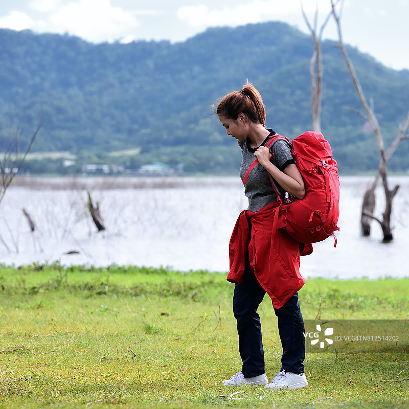 亚洲年轻人背着背包在森林里徒步旅行。图片素材