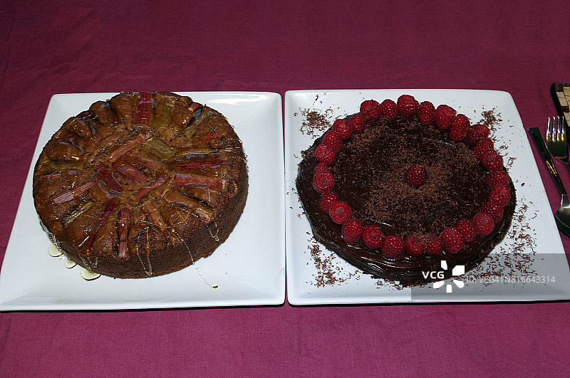 两个家烤蛋糕:一个大黄酸奶油蛋糕和一个巧克力蛋糕装饰树莓和磨碎的巧克力图片素材