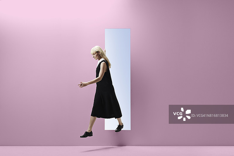 女人踏着有色墙扔出一个长方形的口子图片素材