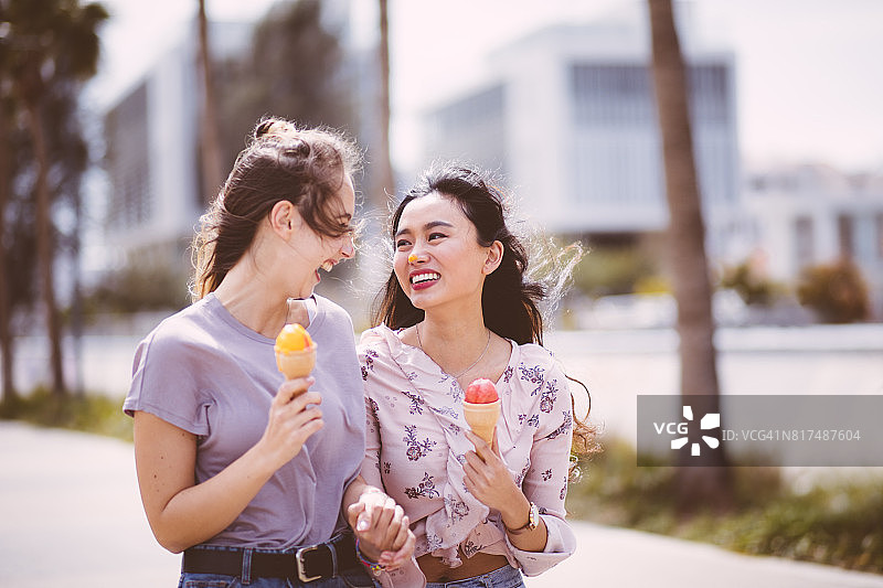 亚洲女孩吃冰淇淋和有乐趣的朋友图片素材