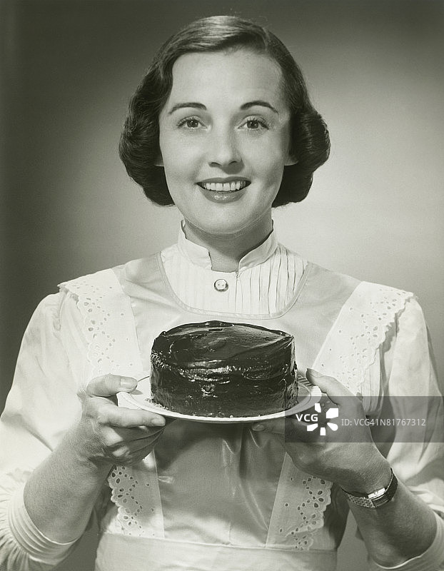 一个女人拿着蛋糕的画室肖像图片素材