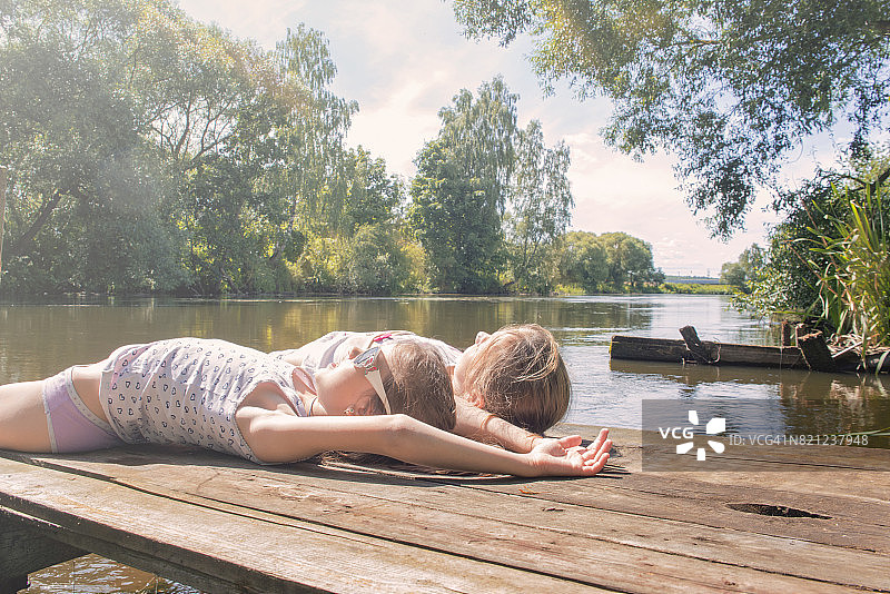 女孩在河边晒太阳。图片素材