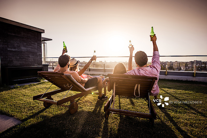 一群朋友在一个阁楼阳台上享受日出的乐趣。图片素材