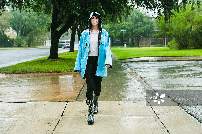 德克萨斯州奥斯汀，一名身穿蓝色雨衣的少女正在下雨图片素材