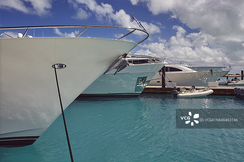 豪华游艇停泊在加勒比海的一个码头，被蔚蓝的热带海洋包围着。图片素材