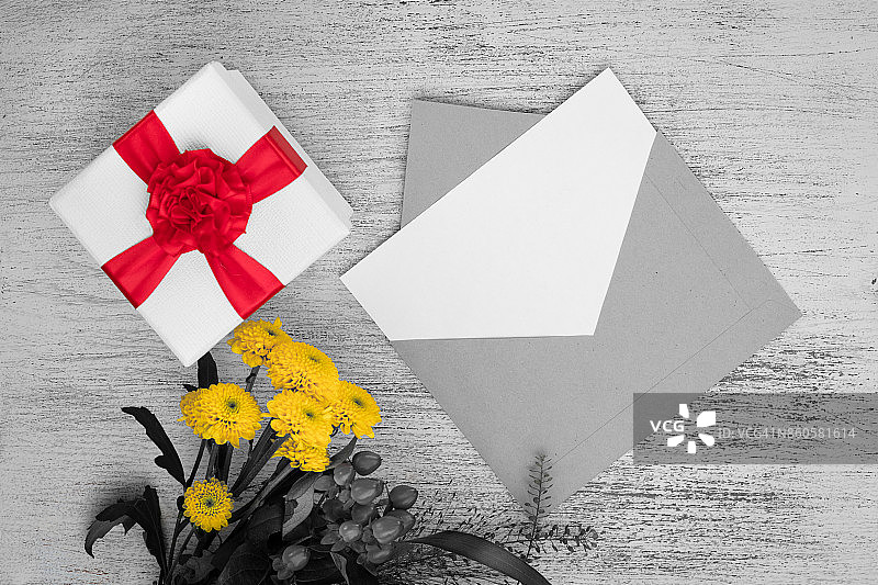 空白卡片，信封，黄花和礼品包装与一个红色蝴蝶结的背景图片素材