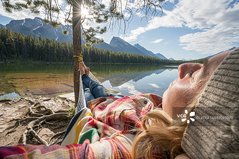年轻女子在湖边的吊床上休息图片素材