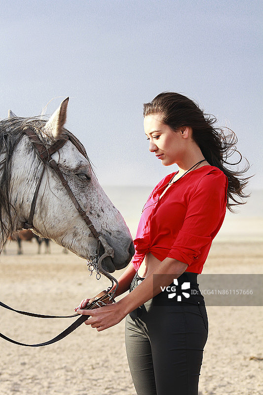 白马和美丽的年轻女子。带着白马的时装模特，图片素材
