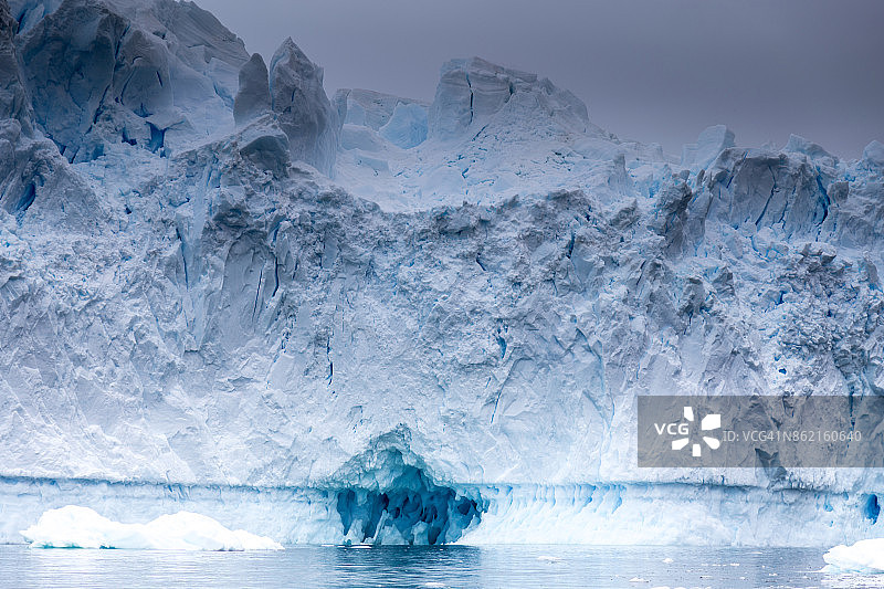 蓝色的冰在这个冰洞里闪耀。图片素材
