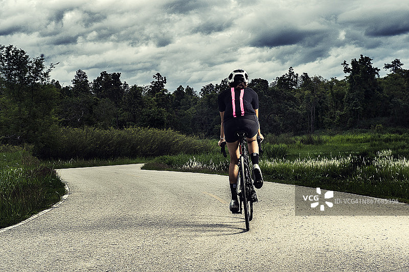 亚洲健康的自行车女孩戴头盔骑自行车和锻炼自行车在短跑跑道和开放的道路图片素材
