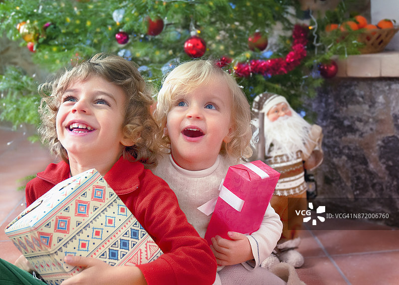 快乐的男孩和女孩享受圣诞礼物图片素材