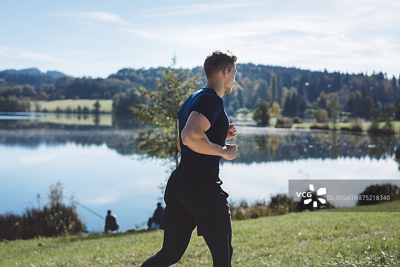 一个男人在湖边跑步图片素材