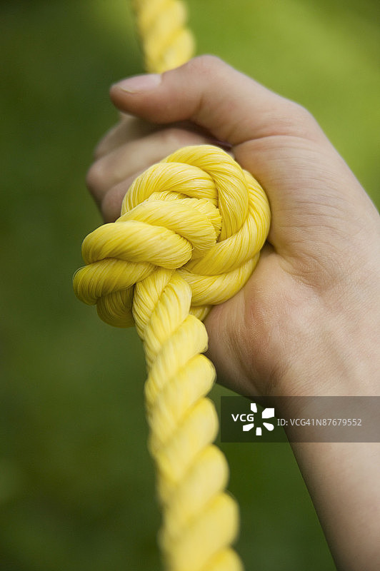 手握打结的绳子的特写图片素材
