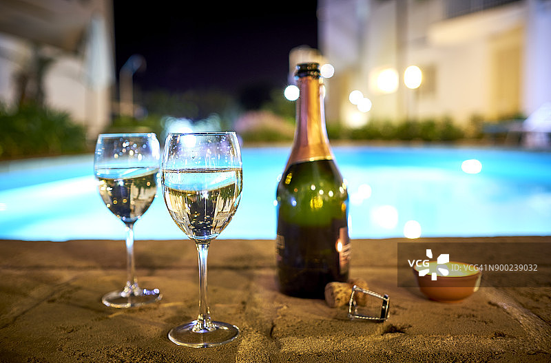 晚上在泳池边喝两杯普罗赛可葡萄酒图片素材