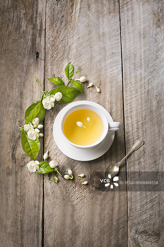一杯茉莉花绿茶在乡村的木制背景。图片素材