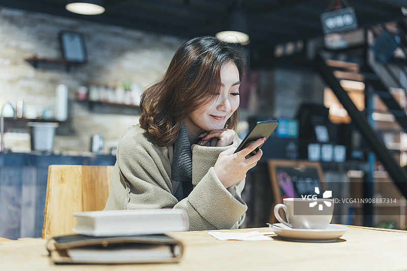 一个在咖啡厅喝咖啡发短信的女人图片素材