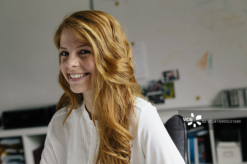 办公室里微笑的年轻女人的肖像图片素材