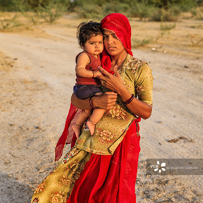 年轻的印度妇女抱着她的小婴儿，印度图片素材