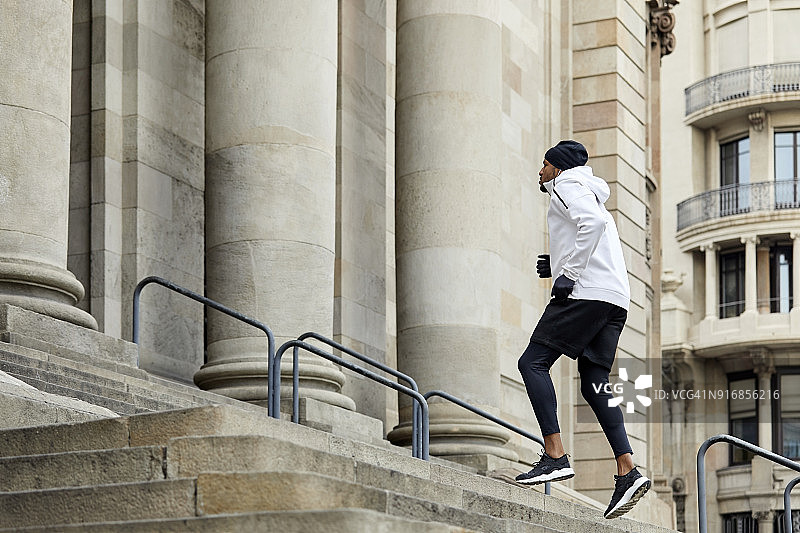 自信的年轻人在城市的台阶上慢跑图片素材