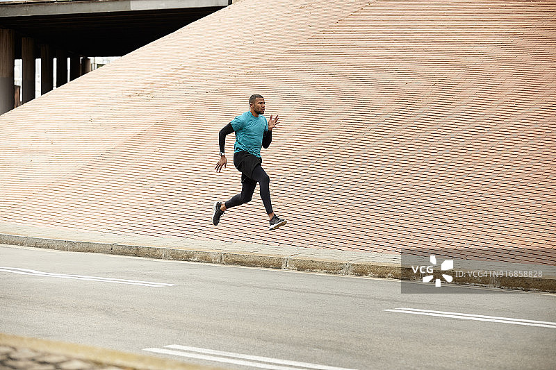 坚定的男运动员在路边慢跑图片素材