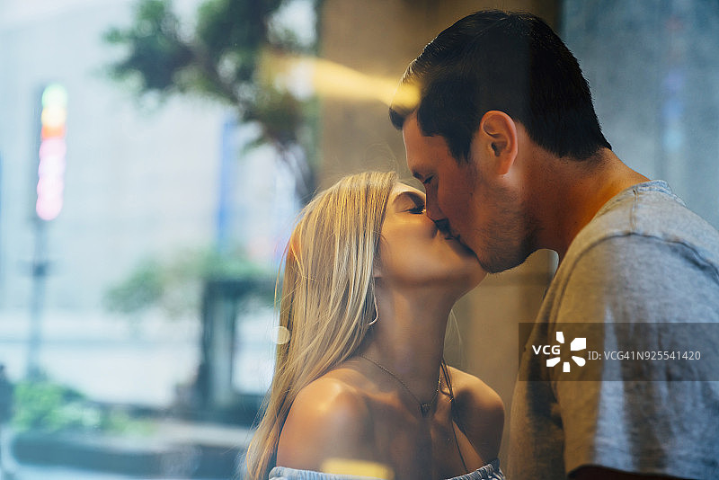 白种情侣在窗后接吻图片素材