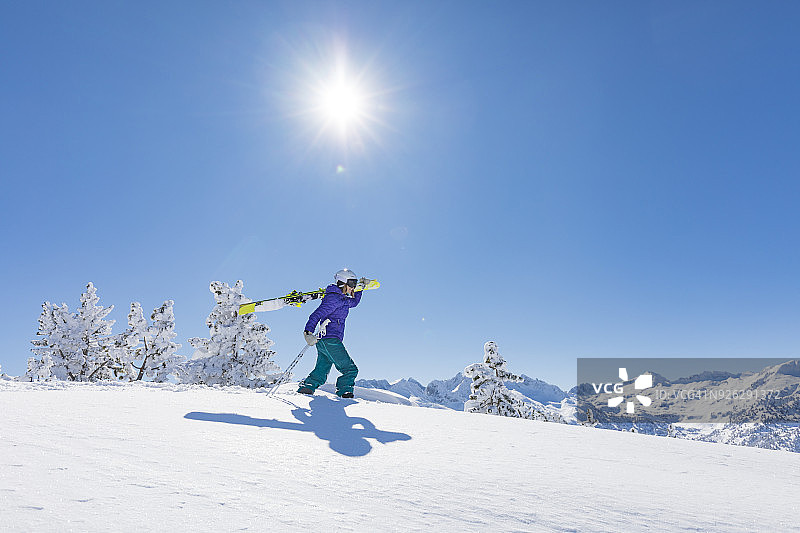 背着她的滑雪板行走的野外滑雪者图片素材