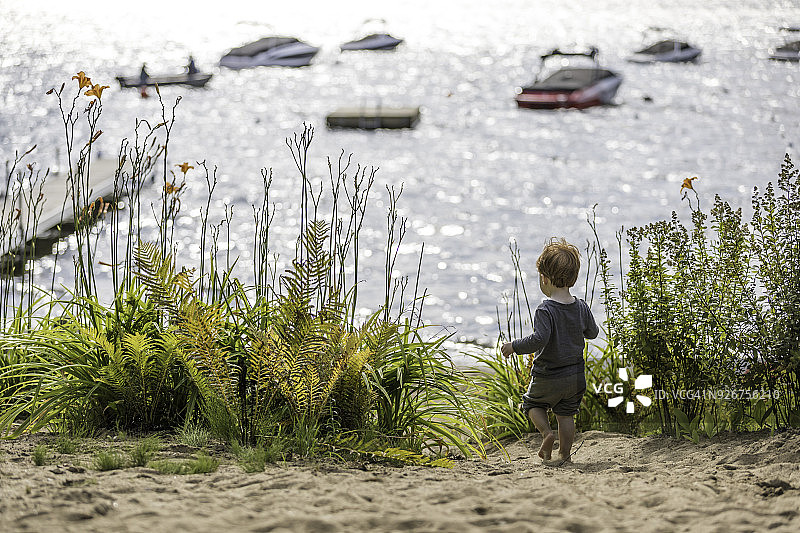 夏日沙滩上独自行走的小男孩图片素材