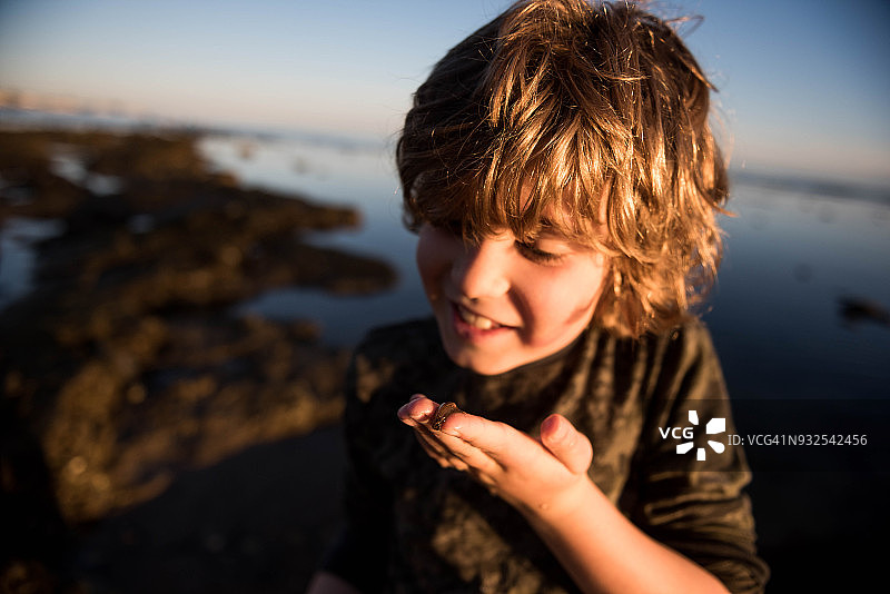 在圣巴巴拉，一个孩子抱着一只裸鳃鳗在检查图片素材