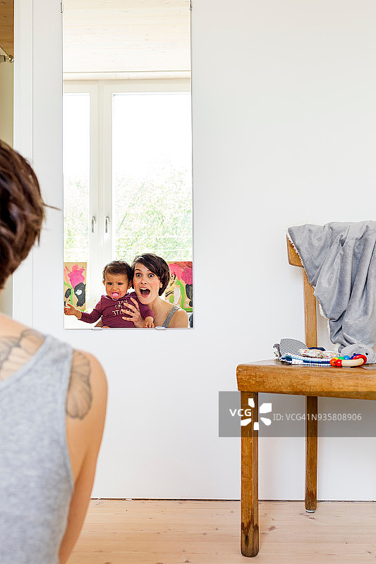 母亲和女婴照镜子，后视镜图片素材
