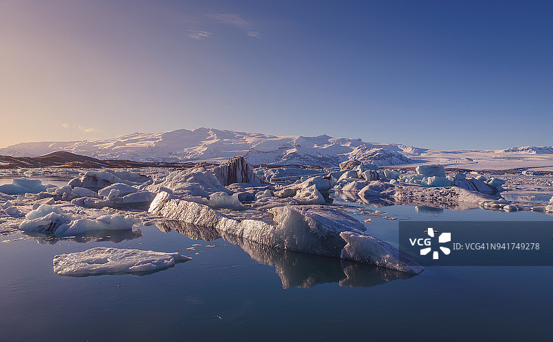 在冬季日落时，冰山被白雪覆盖，冰岛南部的Jokulsarlon冰湖，极地地区图片素材