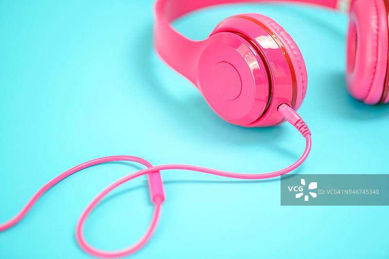 粉色耳机浅蓝色背景，复古或粉彩概念图片素材