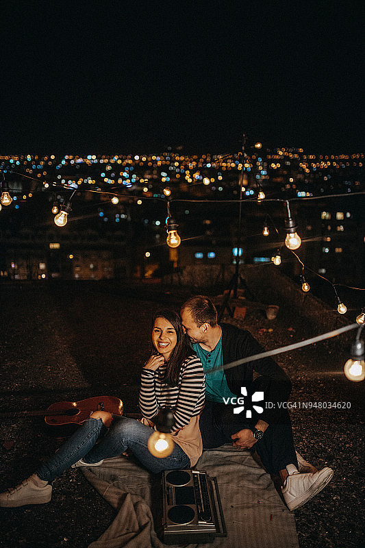 一对快乐的年轻夫妇在屋顶派对上图片素材