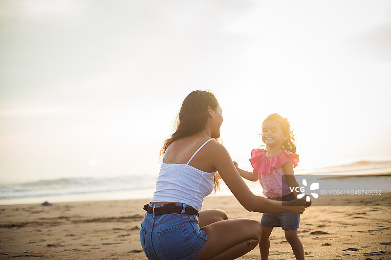 妈妈和小女儿在海滩上玩得很开心图片素材