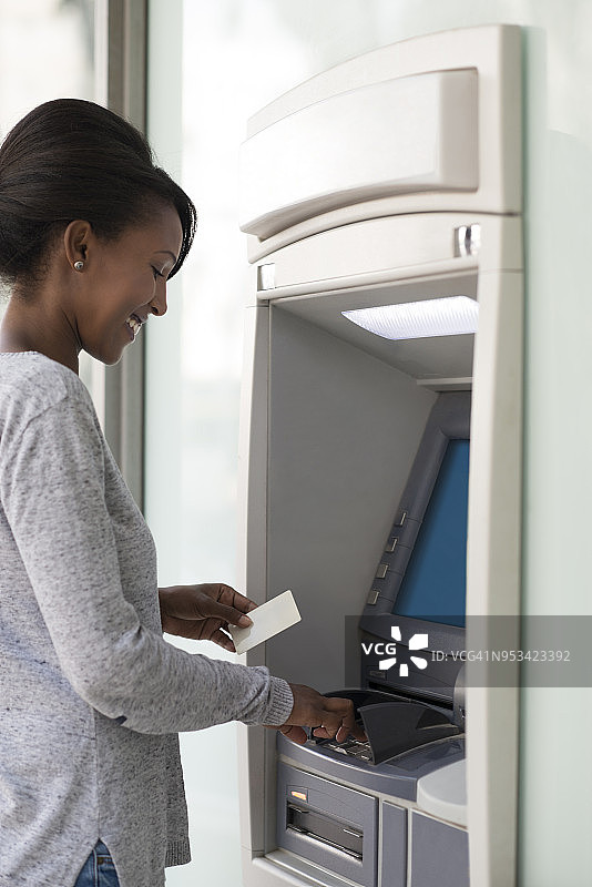 使用银行自动取款机的女人。图片素材