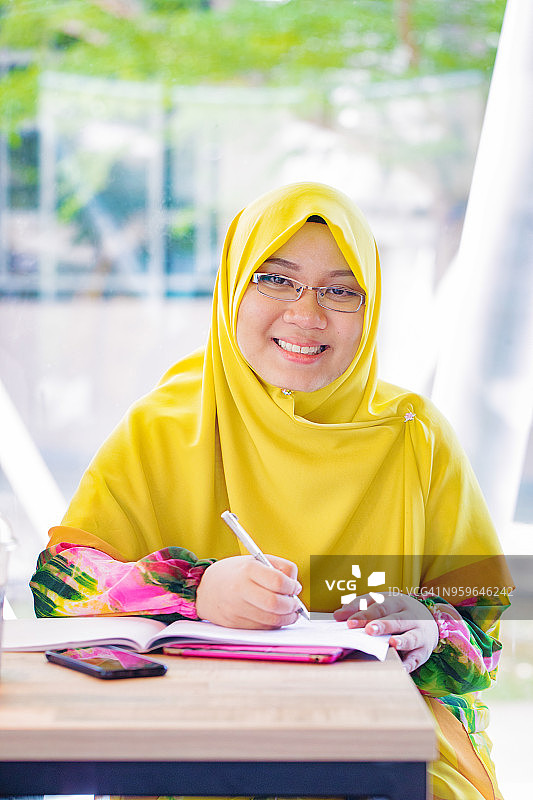 女穆斯林大学生戴着黄色的头巾肖像图片素材