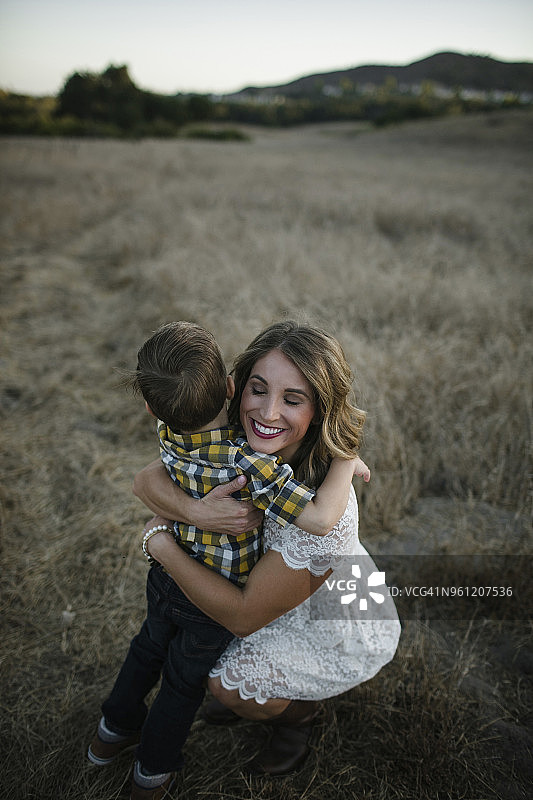 高角度的视角，母亲拥抱儿子，而蹲在地里图片素材