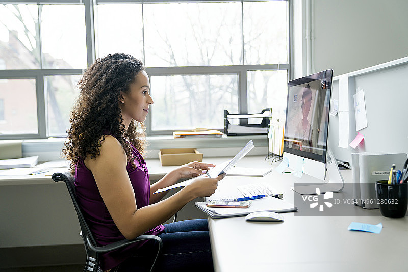 侧面的女商人视频会议与女同事在办公室的桌面电脑图片素材