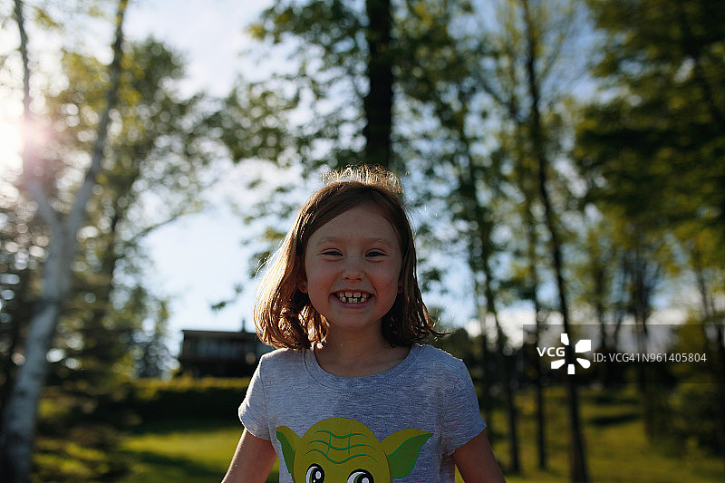 近距离的肖像快乐的女孩站在树图片素材