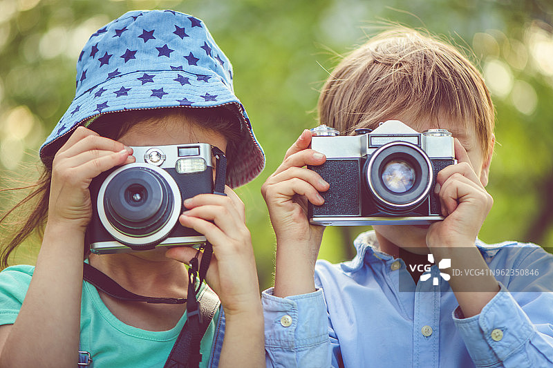 小男孩和小女孩在公园里拍照图片素材